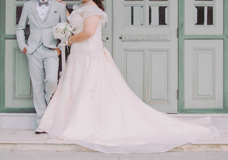 Plus-size-bride-with-elegant-bridal-dress-and-groom-in-suit-happy-newly-wedding-couple-hold-hands-together-in-the-garden